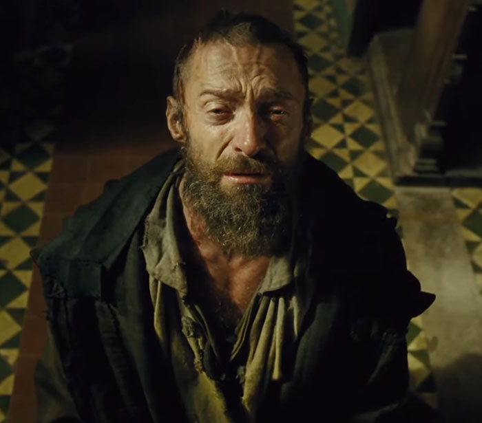 Actor in dramatic scene, sporting a rugged appearance with a beard, channeling 70s style in cinematic setting.