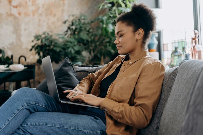 Woman on a sofa using a laptop, focused on discovering relationship truths and decisions about divorce. Woman on a sofa using a laptop, focused on discovering relationship truths and decisions about divorce.
