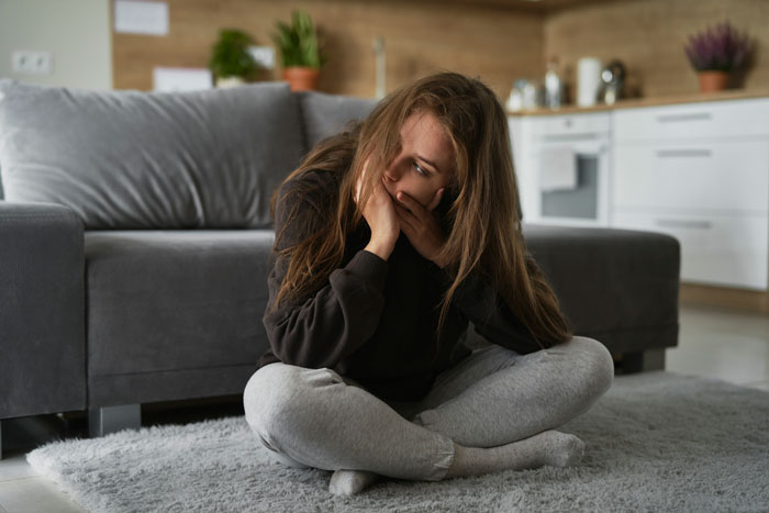 Woman sitting on floor with thoughtful expression, wondering about sister-in-law's actions and possible planned accidents. Woman sitting on floor with thoughtful expression, wondering about sister-in-law's actions and possible planned accidents.