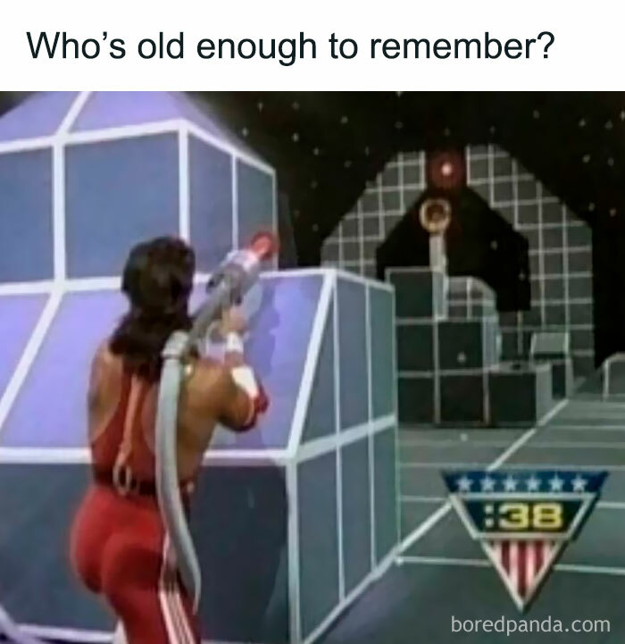 Man in retro game show aiming a laser gun in a sci-fi set.
