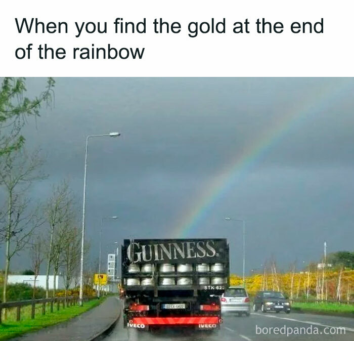 Truck full of kegs under a rainbow, humorous scene captured on a cloudy day.