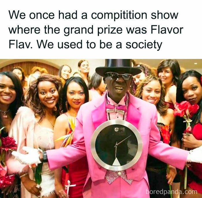 Man in a bright suit with a clock necklace, surrounded by smiling women, reflecting funny throwbacks nostalgia.