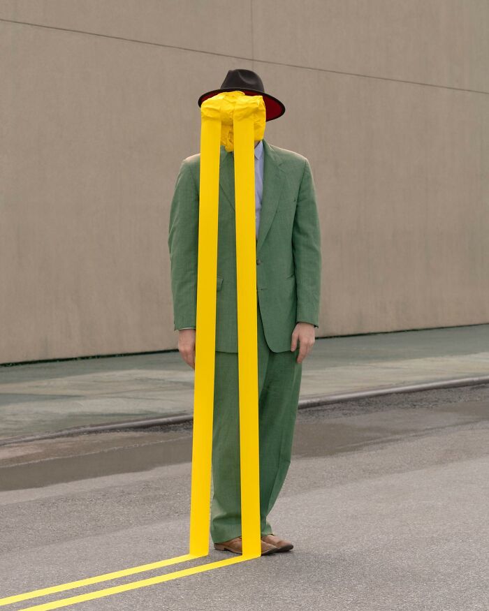 Man in green suit and hat, face obscured by yellow lines, stands in surreal urban landscape by Ben Zank.