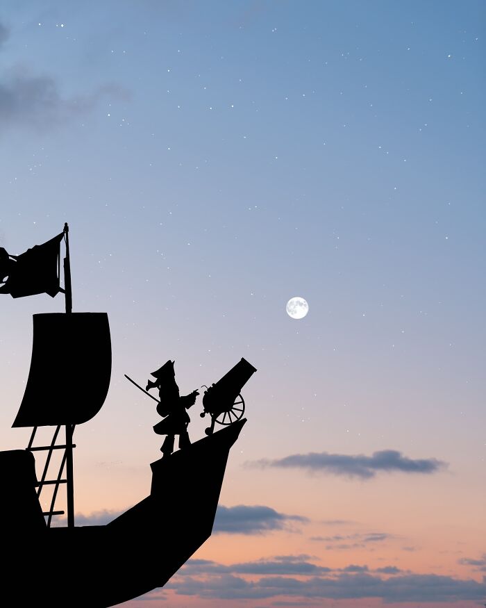 Silhouette photography of a pirate ship against a starry sky with a full moon, captured by Lân Nguyen.