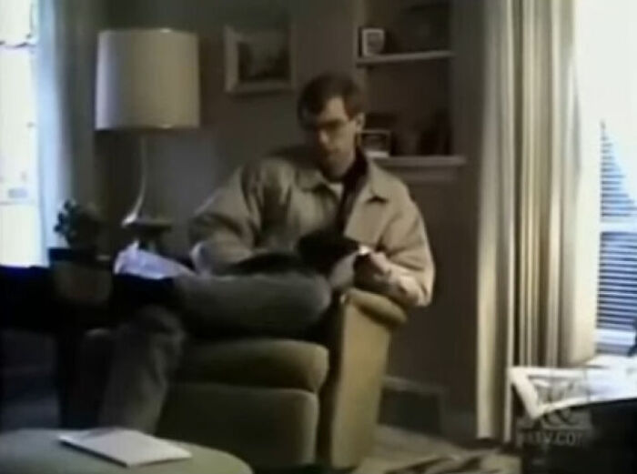 Man in an armchair reading a magazine in a dimly lit room, fitting the creepy photos theme with a mysterious atmosphere.