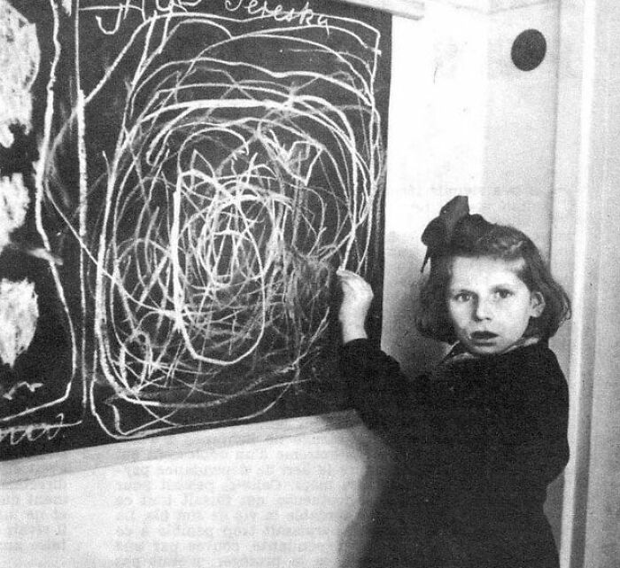 Young girl drawing chaotic lines on a chalkboard, creating a creepy scene with dark history.