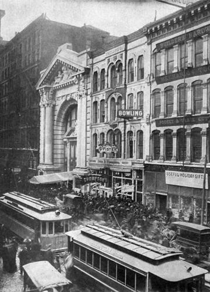 Historic street scene with vintage trams in a bustling city area, capturing an eerie atmosphere of the past.