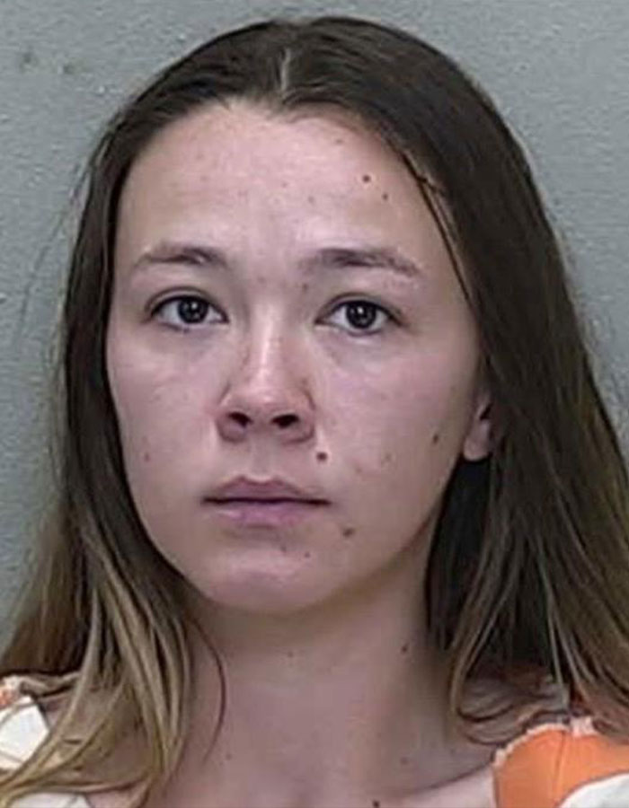 Woman in mugshot facing camera, related to influencer arrest incident.