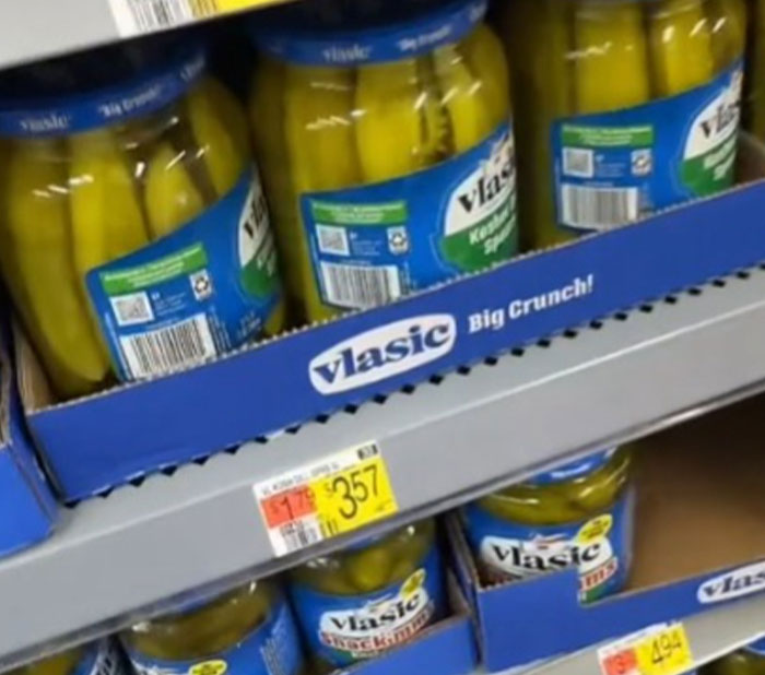 Jars of Vlasic pickles on a grocery shelf with price tags displaying high grocery prices in the US.