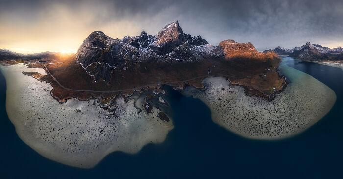 Stunning landscape with rugged mountains and serene waters under a dramatic sky, captured by a talented photographer.
