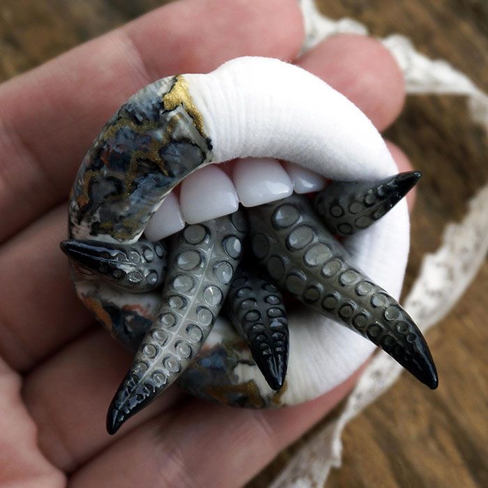 Creepy handmade craft featuring tentacles emerging from a human mouth in a hand.