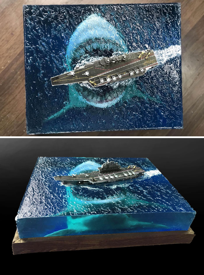 Handmade craft featuring a shark and ship in a detailed, resin ocean scene, combining interesting and creepy elements.