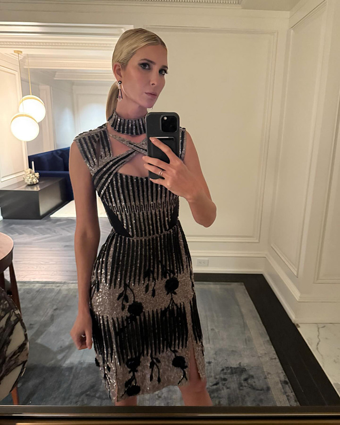 Person taking a mirror selfie in an elegant dress in a sophisticated room setting. Person taking a mirror selfie in an elegant dress in a sophisticated room setting.