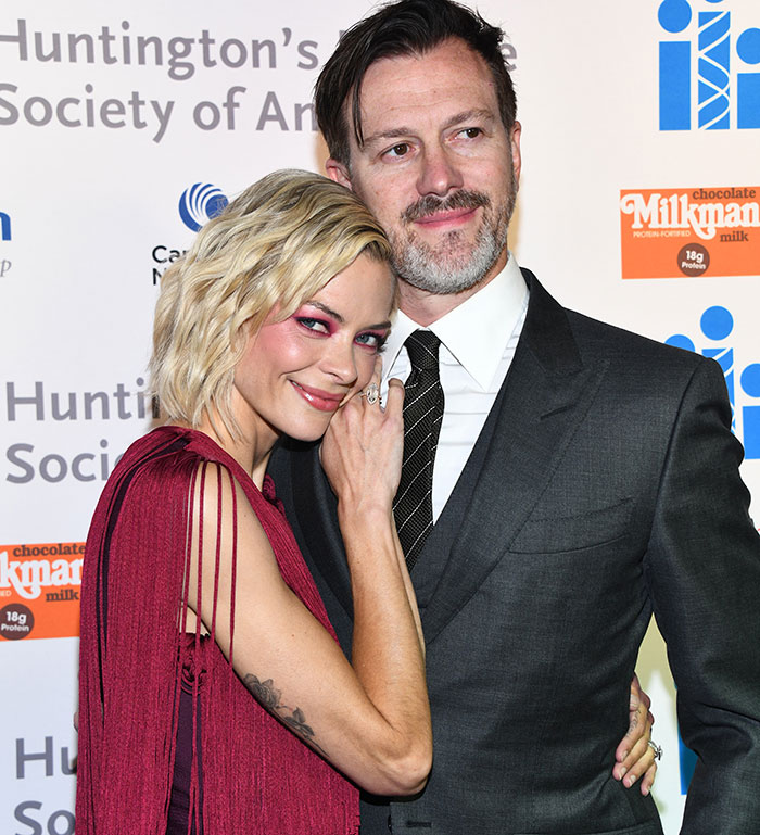 A woman in a red dress poses with a man in a suit at an event, related to Taylor Swift's godson court news.