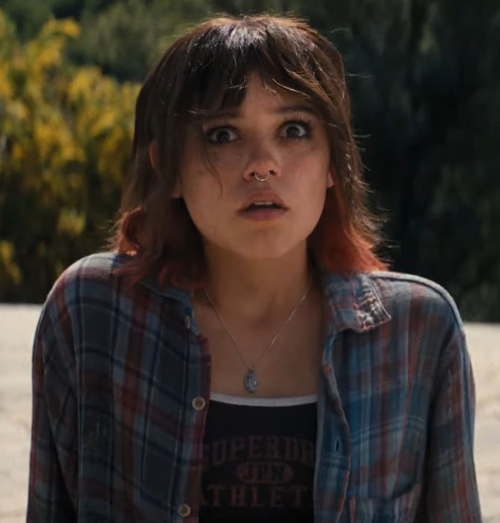 Young woman in plaid shirt looking shocked, set outdoors, related to Iron Man 3 experience with Marvel.