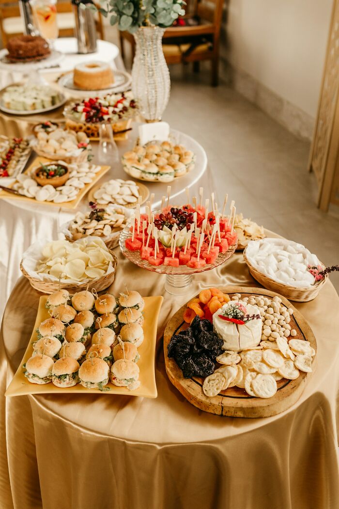 Wedding spread with appetizers, sandwiches, and desserts on elegant tables, highlighting possible red flag elements.