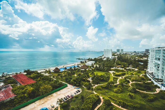 Scenic coastal view with resort buildings and greenery, a destination often considered overhyped by seasoned travelers.