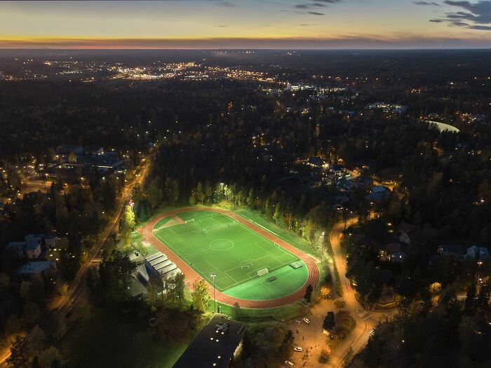 Aerial night view of a soccer stadium illuminated in a quiet suburban area, showcasing one of the cathedrals of soccer.