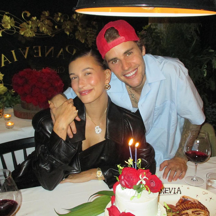 Justin Bieber and Hailey at Disneyland, smiling at a candlelit dinner setting.