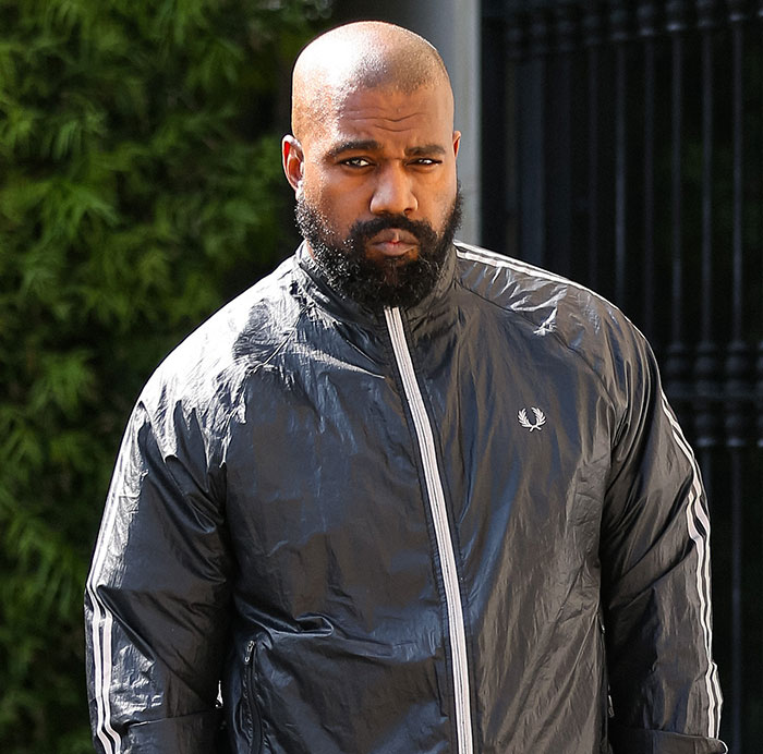 A man in a dark jacket walking outdoors, looking serious. Possible context of human trafficking accusation discussed.