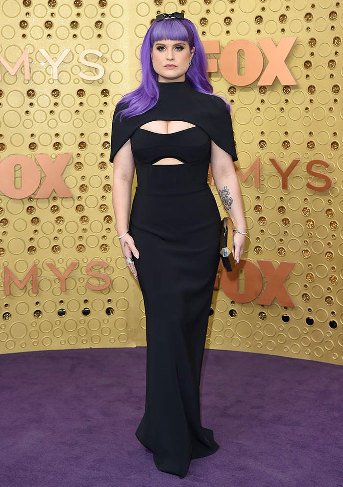 Kelly Osbourne in a black dress on a red carpet.