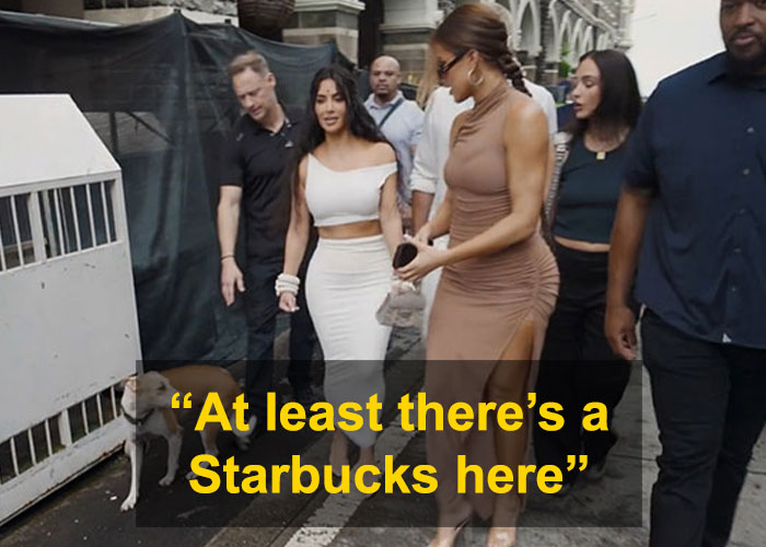 Kim Kardashian walking with a group, surprised by surroundings, with text overlay about Starbucks, in an urban street setting.