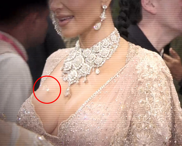 Woman in extravagant outfit, circled spot highlighting lost diamond, sparking publicity claims.