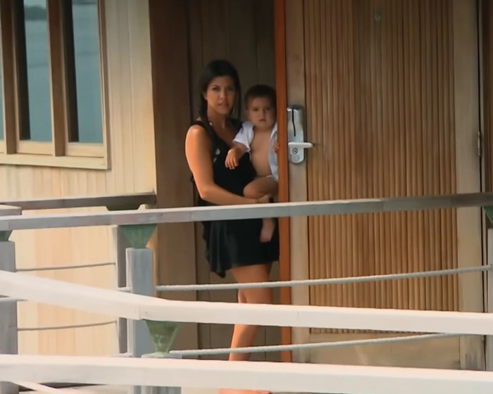 Woman holding a child in a doorway, related to controversy over faking publicity with a diamond.