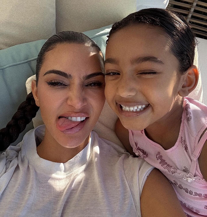 Kim K with child smiling indoors, focused on family moments amid Dr. Phil's warning. Kim K with child smiling indoors, focused on family moments amid Dr. Phil's warning.
