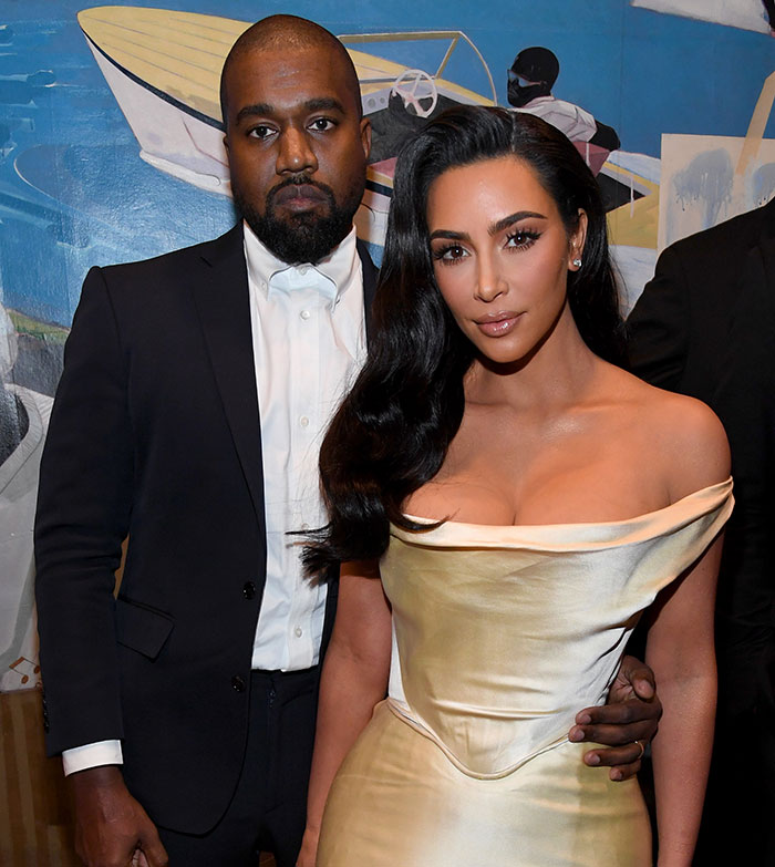 A couple posing together at an event, with colorful artwork in the background. A couple posing together at an event, with colorful artwork in the background.