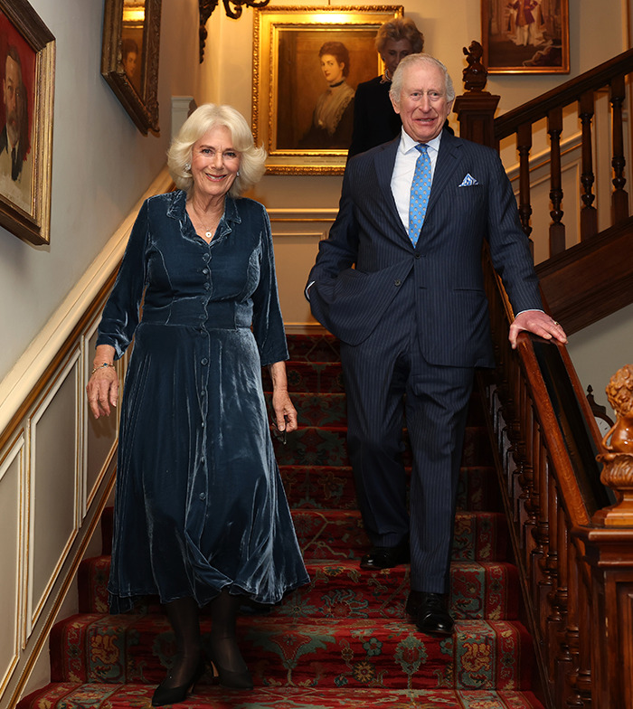 Royal couple descending staircase amid health concerns, dressed elegantly. Royal couple descending staircase amid health concerns, dressed elegantly.