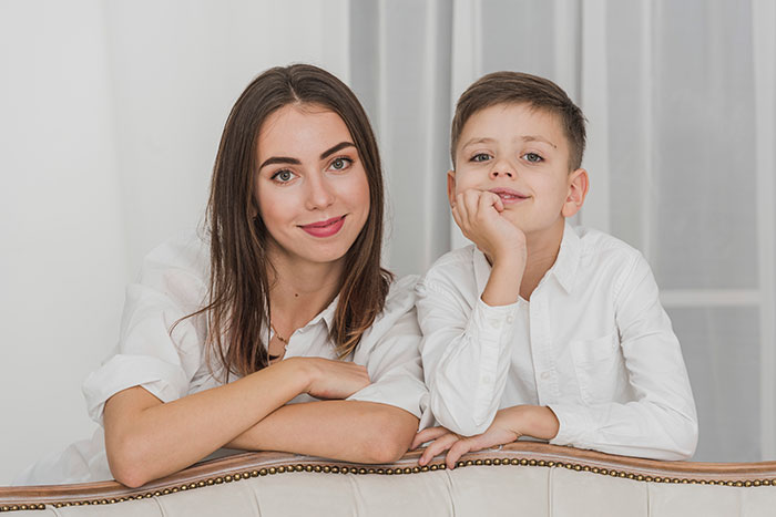 Woman and child in white shirts smiling, representing family-related finance decisions.