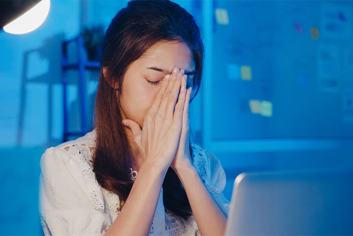 Woman stressed at laptop, might benefit from life-saving tips for stress management.