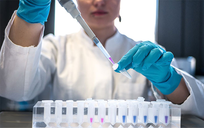 Scientist in lab using pipette for experiment, demonstrating life-saving tips with test tubes.