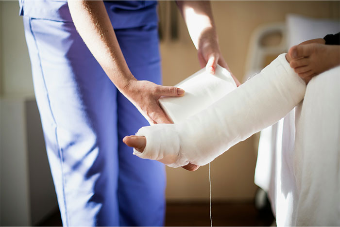 Medical professional applying a bandage to a patient's leg, demonstrating life-saving first aid technique.
