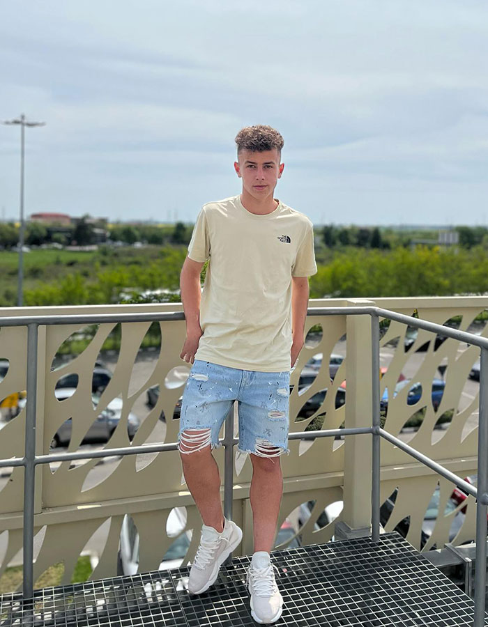 Young footballer in casual outfit standing on an outdoor platform. Young footballer in casual outfit standing on an outdoor platform.