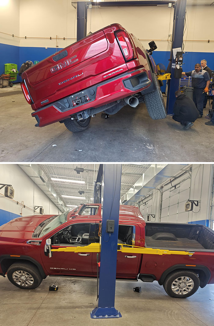 Truck dangerously tilted on a lift in a garage, showing a worker's worst day at work.