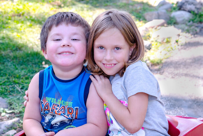 Kids sitting outdoors, smiling together, highlighting a cheerful moment. Kids sitting outdoors, smiling together, highlighting a cheerful moment.