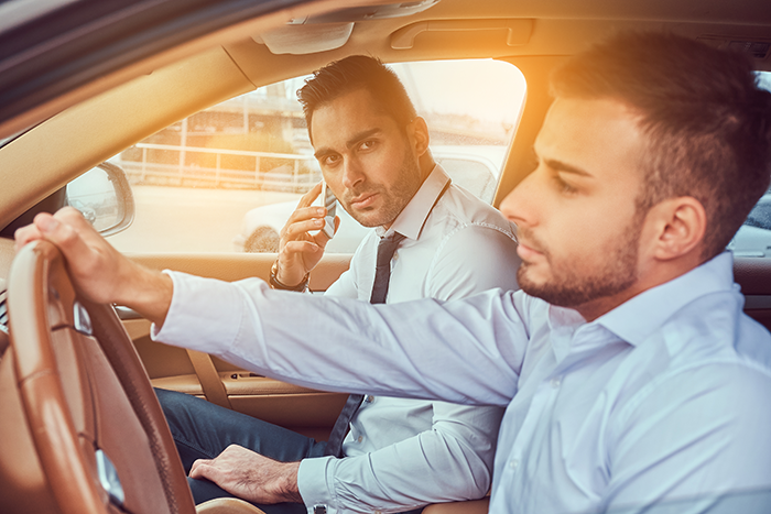 Two men in a car, one is driving, illustrating free ride to work scenario.