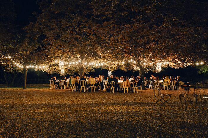Outdoor wedding reception at night with guests seated under string lights, highlighting potential red flags.