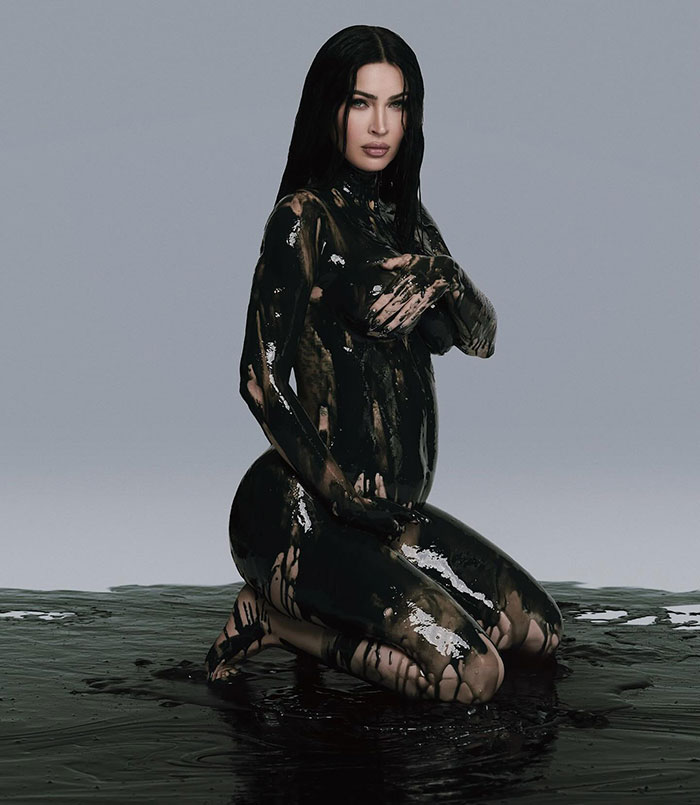 Person covered in black paint, kneeling in a studio setting, related to Celestial Seed announcement.