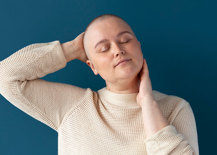A person in a beige sweater, eyes closed, relaxes against a blue background, representing curiosity about men.
