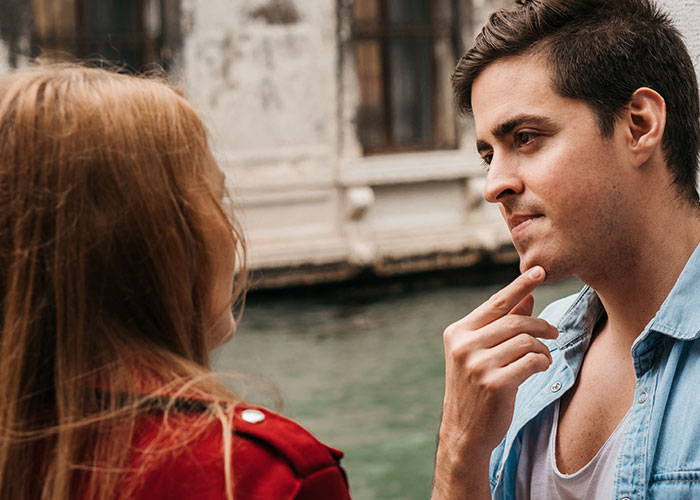 Man and woman in deep conversation by a canal, capturing curiosity about men.