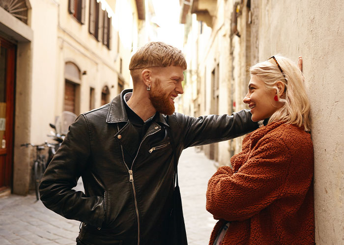 Man and woman having a conversation in a narrow street, highlighting questions about men and interpersonal dynamics.