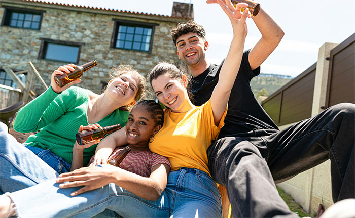 Grupo de amigos divirtiéndose al aire libre, reflejando preguntas curiosas entre hombres y mujeres.