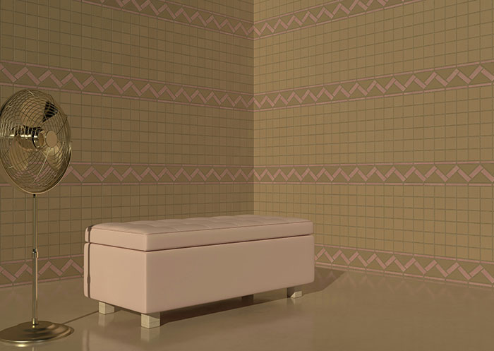 A pink bench and fan in a patterned room with geometric wallpaper design.