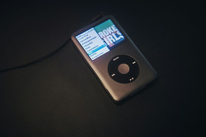Vintage discontinued iPod with a music playlist on screen, evoking nostalgia.