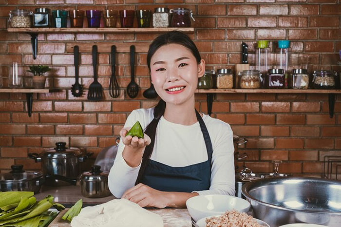 Chinese daughter-in-law smiling in kitchen with Indian and Chinese cooking ingredients. Chinese daughter-in-law smiling in kitchen with Indian and Chinese cooking ingredients.