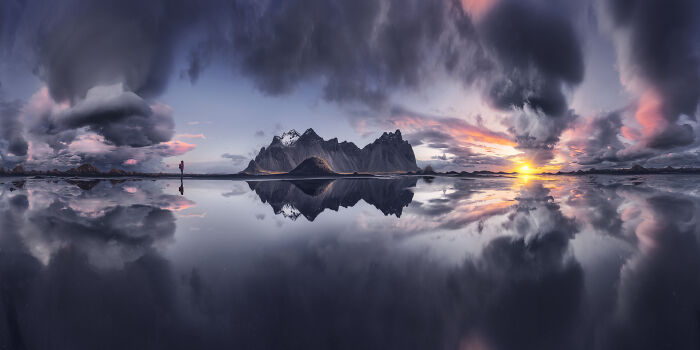 Stunning landscape photography of mountains with starry skies reflecting on water at sunset.