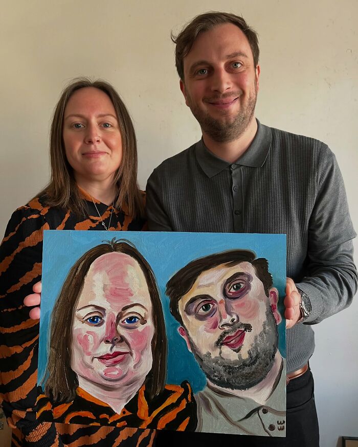 A British artist holding an expressive portrait of two people in vibrant colors.